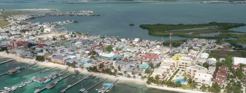 aerial view of boats and houses on narrow stretch of beach in belize