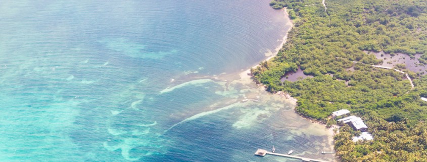 blue water and white sand aerial shot near Barrier reef in the Caribbean