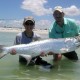 boy holding tarpon after fishing shallows in belize