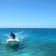 captain cliff driving dingy behind sailing catamaran