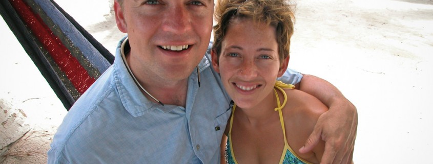 couple in hammock on south water caye belize while on catamaran charter vacation