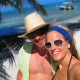 couple pose near blue green waters of belize while on catamaran charter vacation