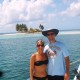 couple possess on catamaran charter with goff's caye island in belize in background