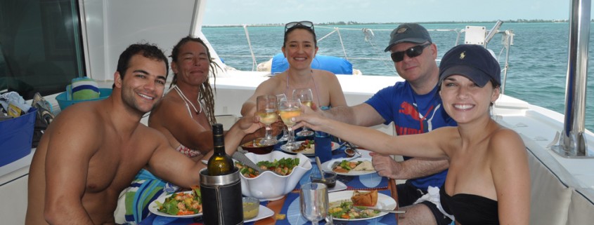 couples toasting wine on catamaran after snorkeling at hol chan