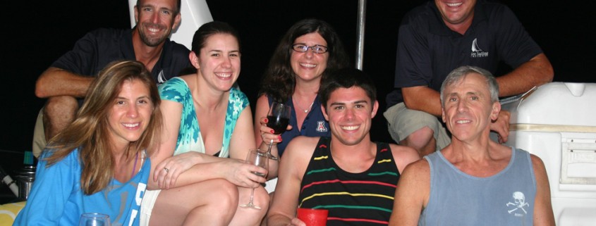 family and crew posing on private yacht vacation in belize