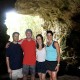 family pose in front of cave entrance on mayan cave tour in belize