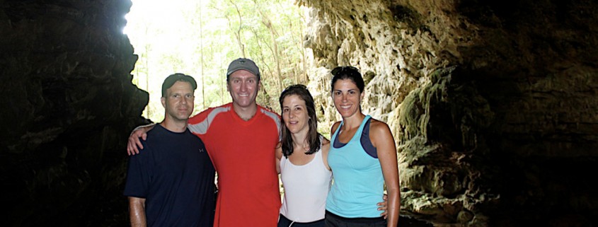 family pose in front of cave entrance on mayan cave tour in belize