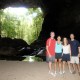 family posting at entrance of cave in belize while on guided cave exploration