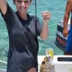 girl holding fish caught in tropical blue waters of belize while on charter