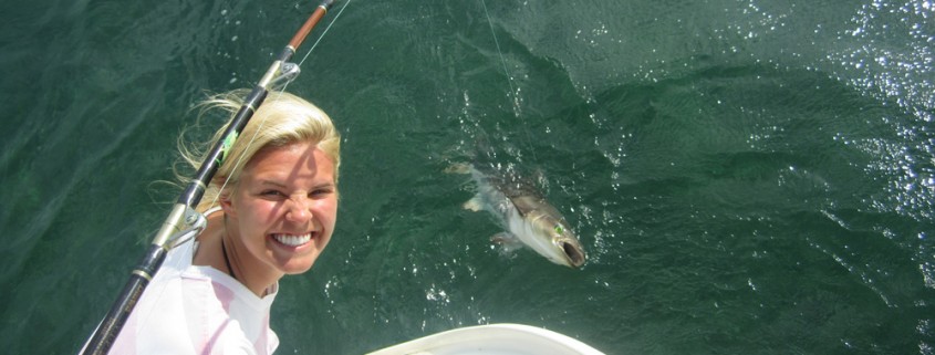 girl poses with fish caught off 50' catamaran sailing in belize