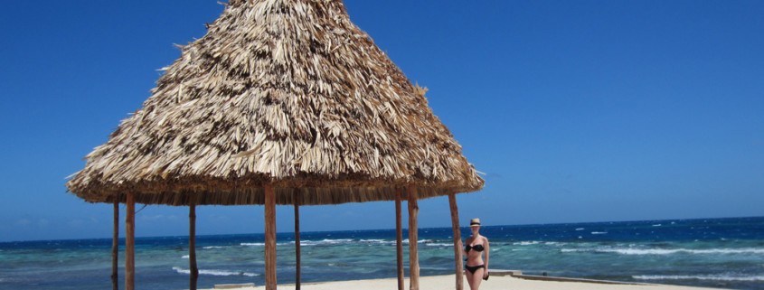 girl relaxing white sand beach hut on remote island while on vacation in belize