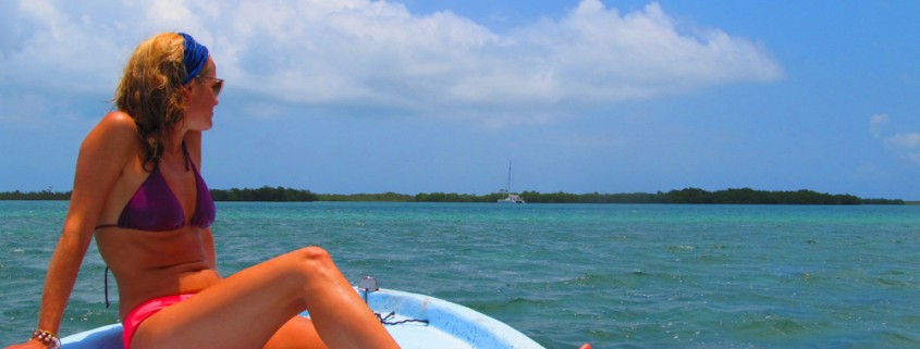 girl riding boat to luxury catamaran while on charter in belize