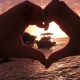 heart hands around boat at sunset near remote island in belize