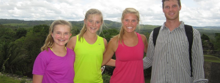 kids and family pose on top of mayan temple with vast jungle on horizon