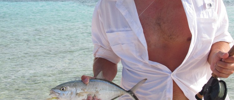 man holding fish caught fly fishing in belize off goff's caye