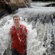 man standing in waterfall while in jungle on vacation with belize sailing vacations