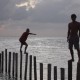 men walking on dock poles near sunset in belize