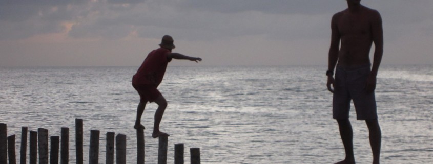 men walking on dock poles near sunset in belize