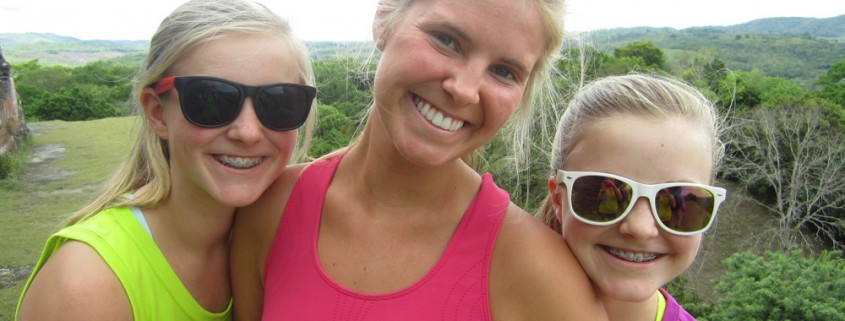 mom and daughters smile on mayan temple in belize