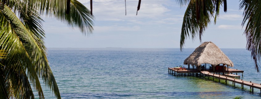 view of tropical paradise and long dock with shaded hut in water