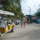 walking with family on white sand streets near shops and golf carts in belize