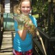 young girl hold huge iguana while on family vacation in belize